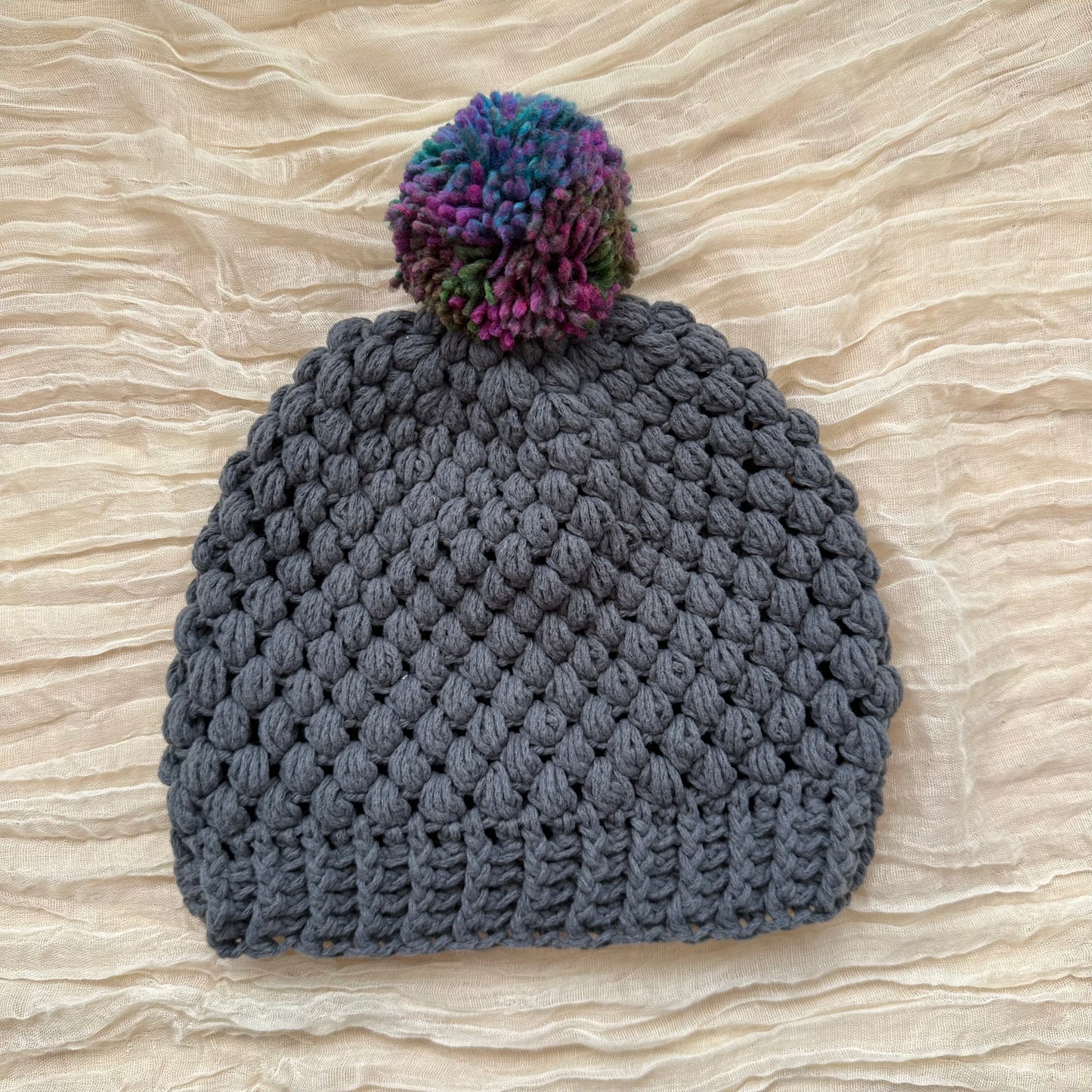 Gorro abullonado gris con múltiples pompones