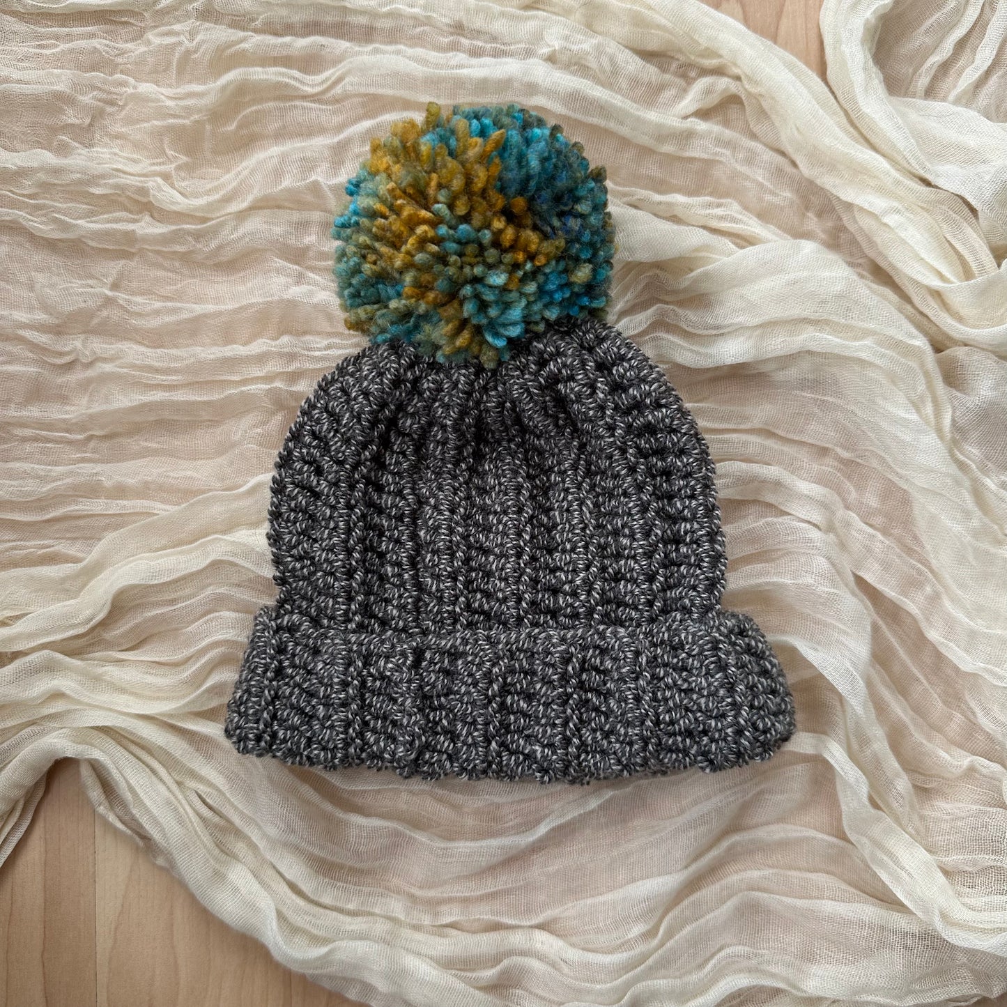 Gorro de bebé gris con pompón multicolor